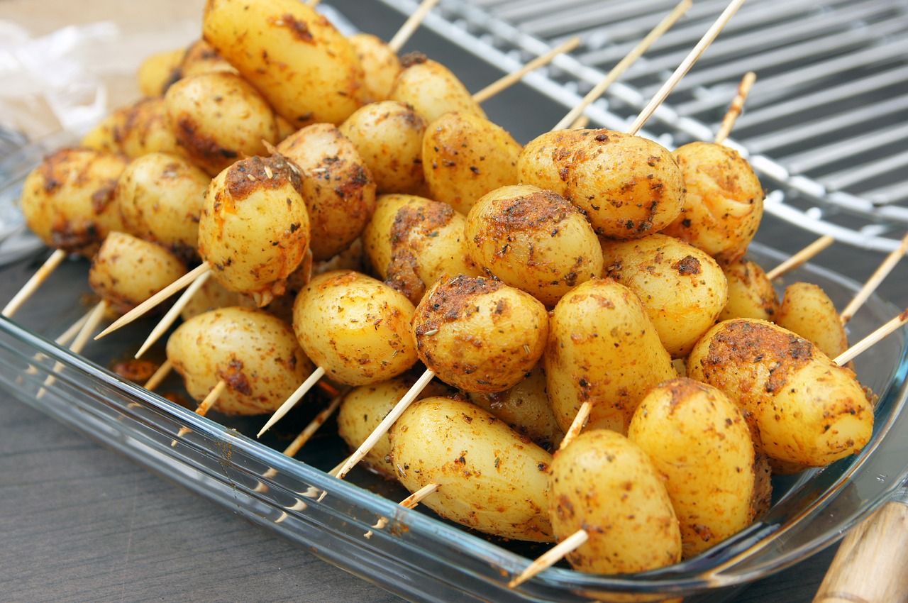 des pommes de terre piquées sur des batonnets en bois pour le barbecue