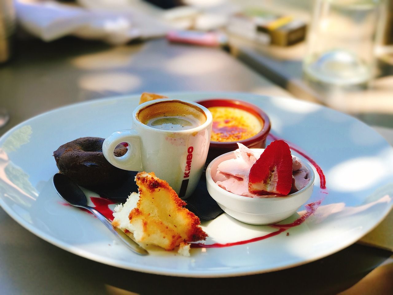 assiette de café gourmand avec espresso, fondant au chocolat, panacotta à la fraise et crème brûlée